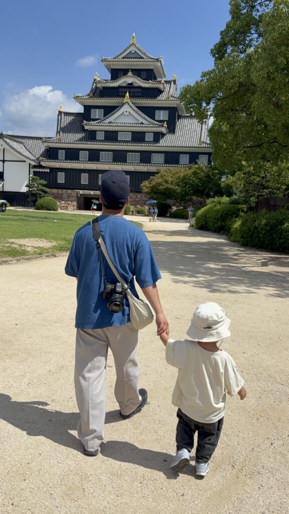 2歳児と手を繋いで岡山城へ向かう家族