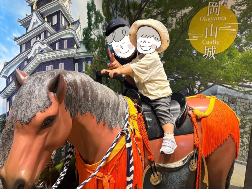岡山城館内の馬の展示で写真を撮る父親と2歳児